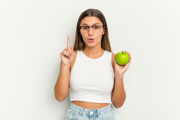 Young Indian woman holding an apple isolated on white background having some great idea, concept of creativity.