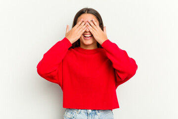 Young Indian woman isolated on white background covers eyes with hands, smiles broadly waiting for a surprise.