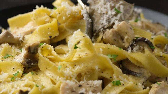 Eating Creamy Alfredo pasta with fork. Italian healthy food.