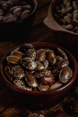 Brown scarlet runner beans in a ceramic bowl on a wooden table. Organic food concept.