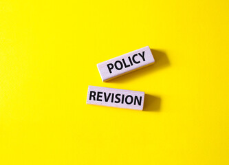 Policy revision symbol. Concept word Policy revision on wooden blocks. Beautiful yellow background. Business and Policy revision concept. Copy space