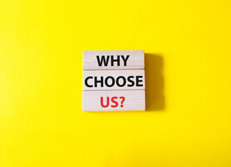 Why choose us symbol. Concept words Why choose us on wooden blocks. Beautiful yellow background. Business and Why choose us concept. Copy space.