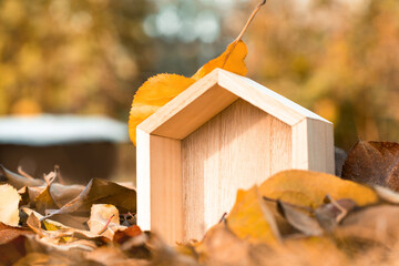 Toy Wooden house in autumn on autumn leaves, copy space. The concept of buying a new home, mortgage, renting