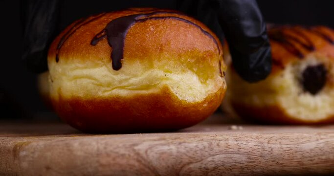 Cut into half a high-calorie doughnut with a sweet filling, dividing into half a fat Berlin doughnut