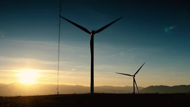 A wind farm or wind park at sunset located in the mountains of Italy Europe and it allows to realize clean energy. It&rsquo;s sustainable, renewable energy for enviromental