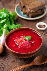 Vegetarian beet borscht in a bowl, wooden table background. Ukrainian cuisine food