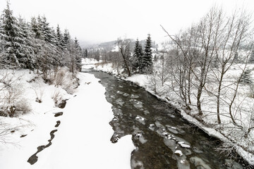 Zimowa rzeka pokryta lodem - obrazy, fototapety, plakaty