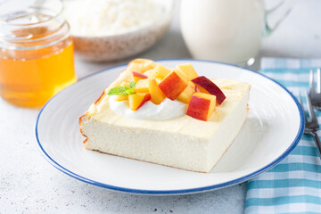 Cottage cheese casserole, zapekanka, ricotta breakfast cake served with greek yogurt, peach and honey. Healthy food rich in calcium and proteins, low carbohydrate diet
