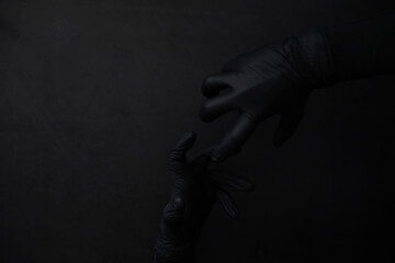 Background of hands in gloves. Black gloves. Hand gestures in black gloves.