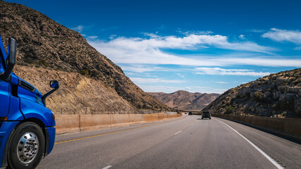 The curving entrance road between rocky hills and valley to Red Rock Canyon National Monument, near...