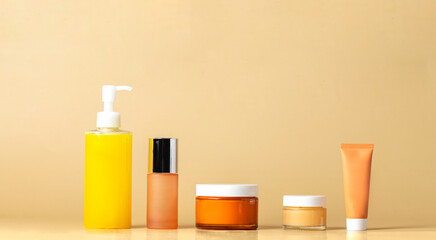 Five step skincare routine concept. Cosmetic product  cleanser, toner, cream, eye serum, spf protection on beige background.  Abstract cosmetic bottles