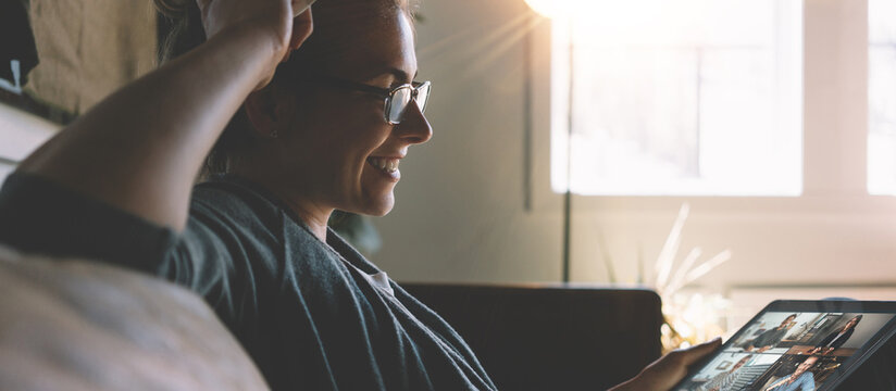 Smiling woman has video call conference with her remote team. Tablet computer with camera teamwork