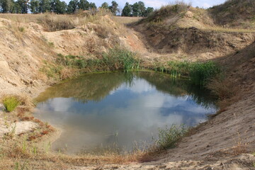 A small pond between sand dunes