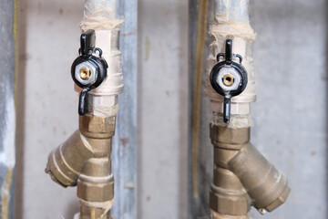 Black brass ball shut-off valves on water supply pipeline in the house, plumbing and construction concept