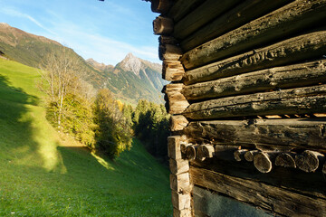 Herbstlandschaft in den österreichischen Bergen mit Holzwand einer Hütte
