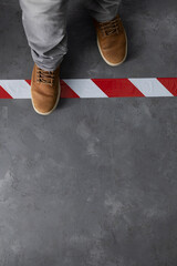 Man stepping over signal warning tape  at cement floor background. Moving forward  concept idea