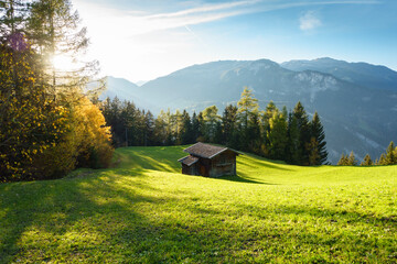 Herbstlandschaft in den österreichischen Bergen mit chalet auf einer Waldlichtung
