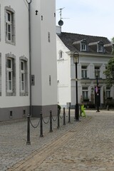 Vertical shot of the sidewalk posts against a white building background