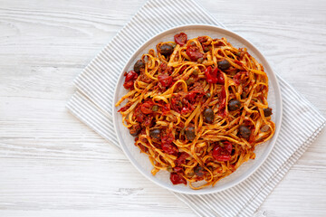 Homemade Tuna Linguine Pasta with Tomatoes, Olives and Capers on a Plate, top view. Overhead, from above, flat lay. Copy space.