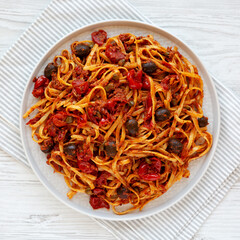 Homemade Tuna Linguine Pasta with Tomatoes, Olives and Capers on a Plate, top view. Overhead, from above, flat lay.