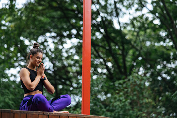 Young woman is practising yoga sitting in the lotus position