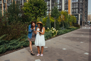 Fototapeta na wymiar Two happy tourists with a phone on a city street