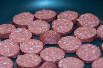 Sliced Turkish sucuk fried in a pan. 