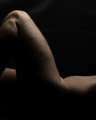 closeup of sensual nude male fitness model with focus on bare torso and legs