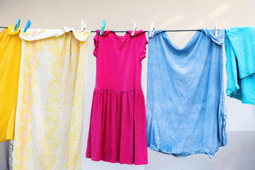 Colored laundry dries on a clothesline after washing.
