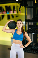 Fototapeta na wymiar Young woman doing exercises with ball at the gym