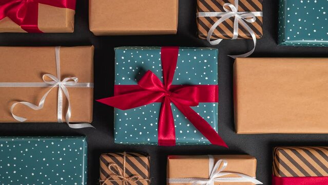 Many Christmas gift boxes with red ribbon on the table. Stop motion animation. Space for text. Mockup.