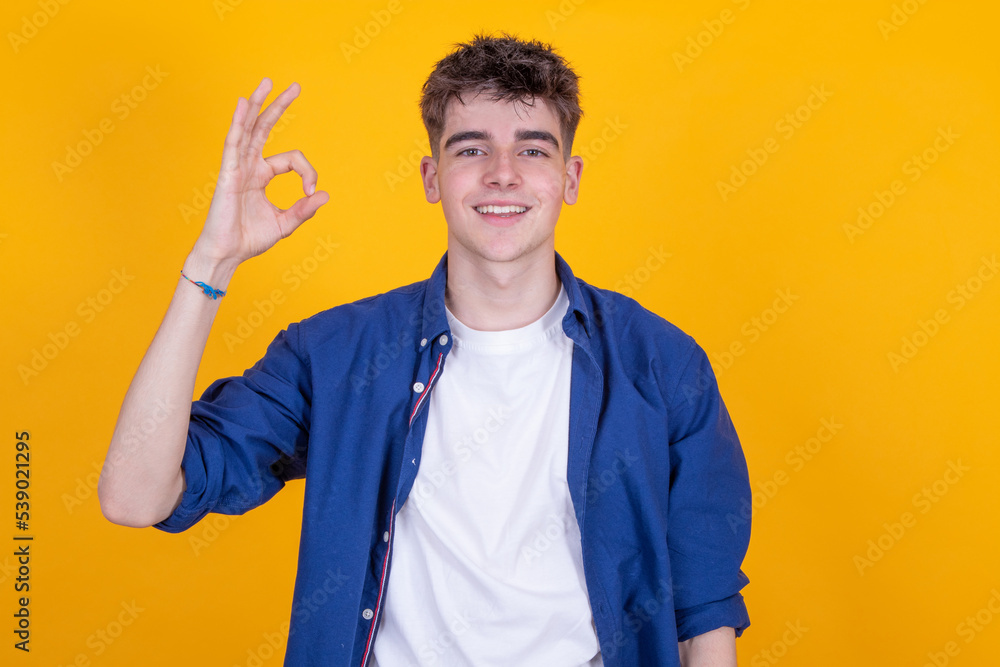 Wall mural isolated young man with okay or approval sign