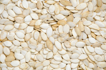 Background, unpeeled pumpkin seeds closeup.