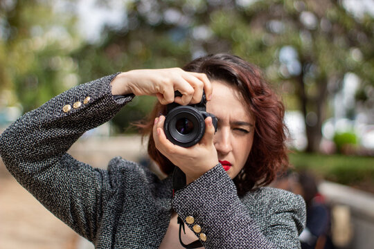 Mujer haciendo fotos en un parque de Madrid.