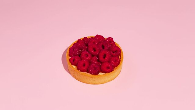 Raspberry tart is eaten piece by piece. Stop Motion Animation. Pink background. 