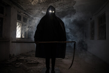 death with scythe standing in the dark hall of abandoned building. - obrazy, fototapety, plakaty