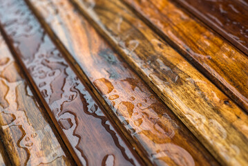 Closeup of rain drops on wooden table at the closed restaurant terrace in the street