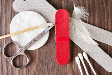 Wooden display with manicure accessories, scissors, nail file, cotton pad
