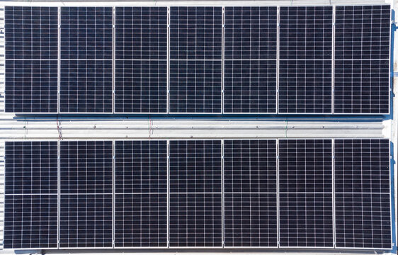 Solar panels, photovoltaic, for the capture of solar energy, with a top view made with a drone, without any person or object in the image besides the plates.
