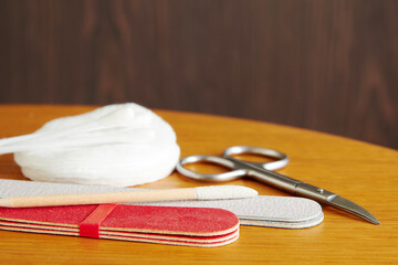 Manicure tools, scissors, nail file, cotton pad on the worker table in the salon