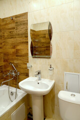 A fragment of the interior of the bathroom with a washroom and a mirror