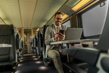 Fototapeta na wymiar Formal wearing business man traveling to work by train. Business man is working while traveling, using laptop, mobile phone, and taking notes. Business man planning goals and meetings