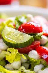 Fresh lettuce macro shot. Salad with baby mozzarella cherry leaves iceberg. Olive oil in salad. Salad with drops of oil on vegetables. Cucumber close-up. Fresh vegetables in a salad
Сucumber in 