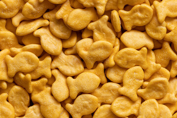 Goldfish cookies background. Top view of fish-shaped salted crackers. Small biscuits.