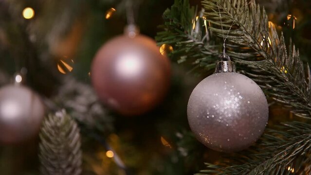 Classic Christmas New Year decorated New year tree with silver pink ornament decorations toy and ball and defocused garland lights. Modern classical holiday design. Christmas eve at home