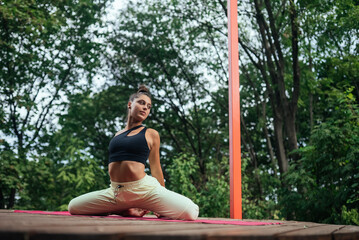 A young woman in doing yoga in the yard