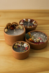handmade aromatic candles with dried flowers above and on the side