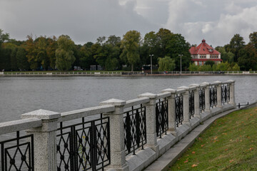City embankment of Upper Pond in Kaliningrad in the cloudy day. Curly white stone and metal fence...