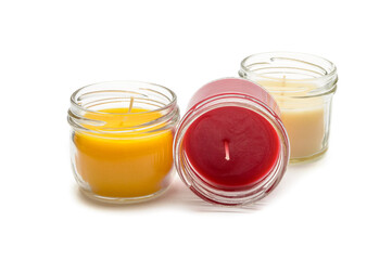 a set of multicolored scented candles in transparent jars on a white background