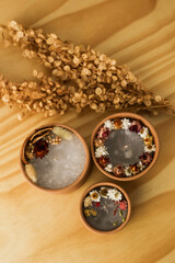handmade aromatic candles with dried flowers above and on the side